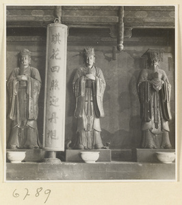 Interior view of Da jue si showing an inscription and three shrine figures, one with a mian liu hat