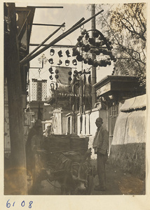 Shop signs for a bead shop (left), coiffure frame shop (center left), comb shop (center bottom), and unidentified shop (right)