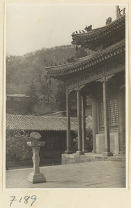 Terrace with a sundial and corner of a double-eaved building with roof ornaments at Jie tai si