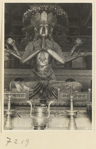 Temple interior at Jie tai si showing altar with a six-armed Bodhisattva