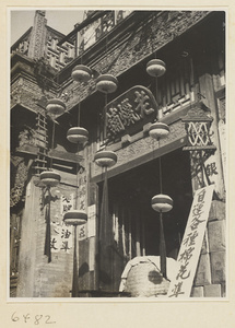 Facade of a shop showing shop signs for candles (left), cotton (center), and wool (right)