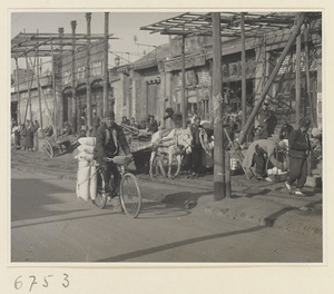 Man riding bicycle loaded with sacks