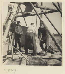 Men drawing water from a well to irrigate a field