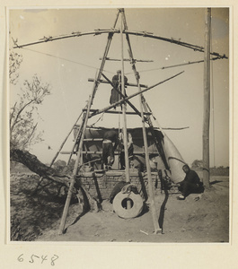 Men drawing water from a well to irrigate a field