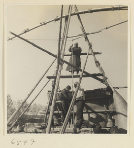 Men drawing water from a well to irrigate a field