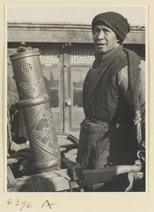 Muslim candy vendor with cart and copper sign