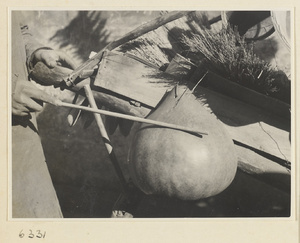 Household goods vendor striking a musical instrument called a pao