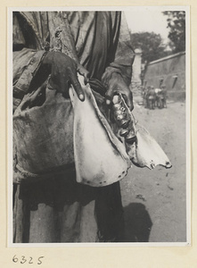 Street entertainer holding cowbone clappers and bells