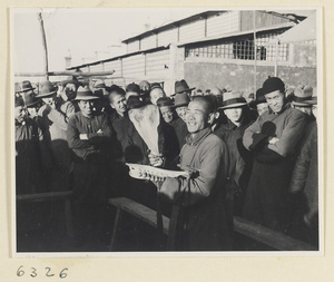 Street entertainer attracting a crowd with cowbone clappers and bells