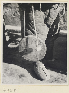 Toy vendor holding a gong called a tong luo