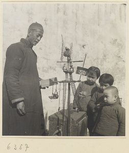 Street entertainer and children watching performing mice show