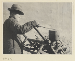 Ironware vendor striking a pot to attract customers