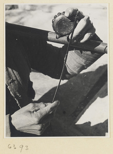 Itinerant vendor striking a drum called a xiao gu