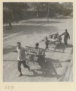 Family pulling two carts in the street