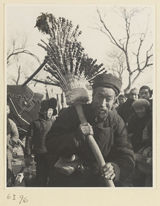 Street vendor hawking candied fruit called tang hu lu from a pole stand