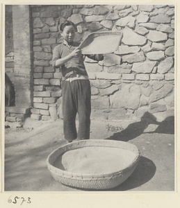 Woman pouring grain into a basket