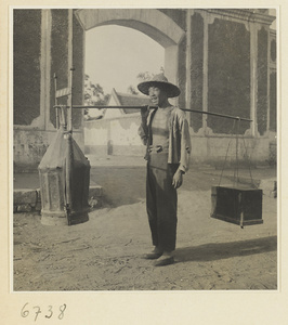 Street vendor carrying boxes of equipment on a shoulder pole