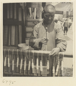 Man weaving a door curtain