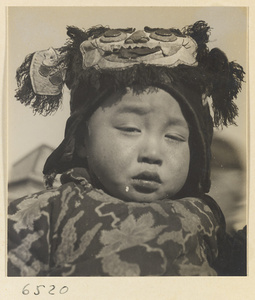 Child wearing a hat with animal-face motif