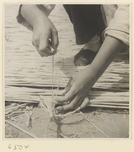 Man weaving a mat at a mat-making shop