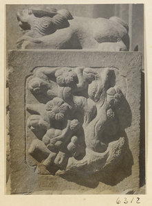 Carved door stone with floral motif and animal finial