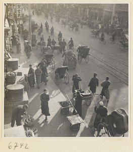 City street with produce stand and bicycle and rickshaw traffic