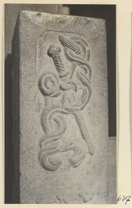 Carved door stone with sword, knot, and fly whisk motifs