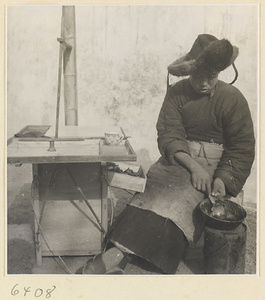 Tracery candy vendor at his stand heating candy on a stove