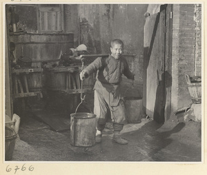 Man carrying buckets suspended from a shoulder pole