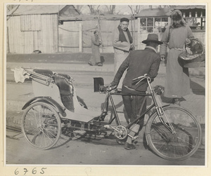 Man leaning against a trishaw in a street