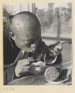 Man eating shao bing and soup at food vendor's stand