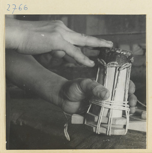 Man working on the wooden body of a stringed instrument in a workshop