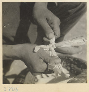 Woman beginning to braid twisted husks to make a maize straw cushion