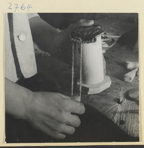 Man working on the wooden body of a stringed instrument in a workshop