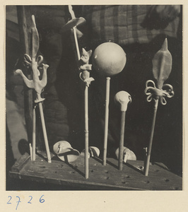 Molded candy forms mounted on bamboo sticks displayed on a candy vendor's stand