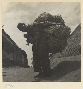 Scrap-paper collector with bundles of paper on his back