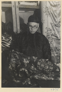 Man holding a piece of embroidered silk cloth