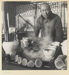 Food vendor selling shao bing (烧饼 sesame cakes) and soup at his stand