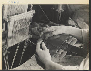 Man at a loom weaving anklebands