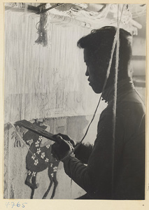 Man weaving a carpet on a loom