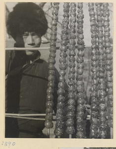 Street vendor hawking strings of candied fruit called tang hu lu at New Year's