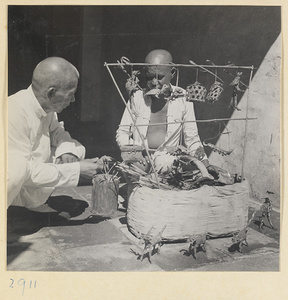 Street vendor selling reed toys at his display stand