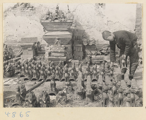 Boy setting out roof ornaments in the courtyard of a tile and brick factory near Mentougou Qu