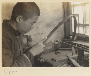 Man using a band saw to cut jade in a workshop