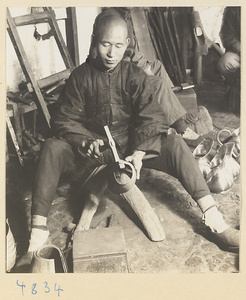 Coppersmith hammering a piece of metal in a workshop