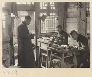 Silversmiths at workbenches in a workshop