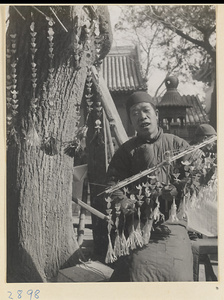 Vendor at Bai yun guan selling paper money in the form of shoes to burn as offerings during New Year's