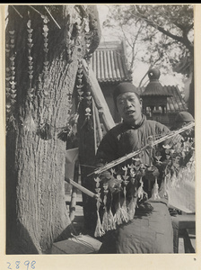 Vendor at Bai yun guan selling paper money in the form of shoes to burn as offerings during New Year's