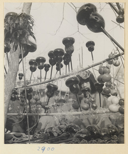 Street vendor's stand displaying gourd-shaped glass trumpets called bu bu deng at New Year's