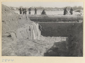 People storing blocks of ice underground